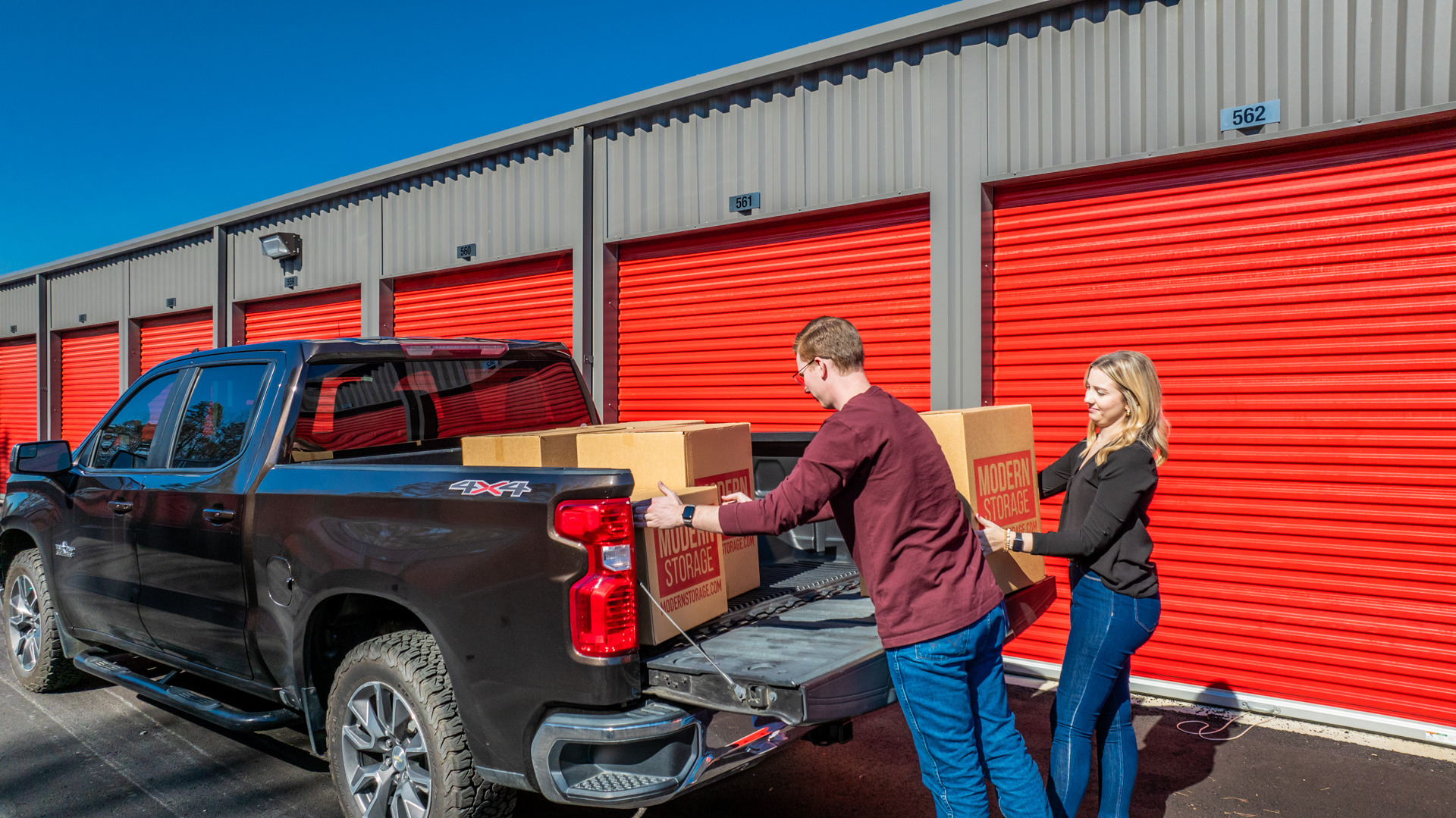 Organized moving boxes and furniture stored inside a climate-controlled storage unit during a home relocation